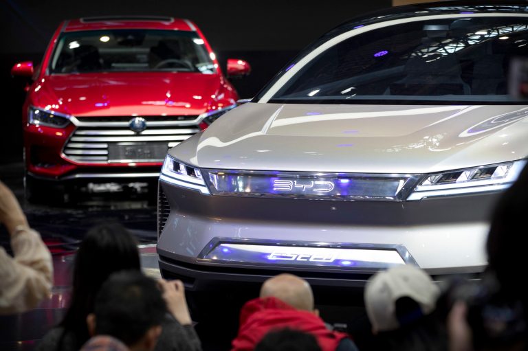 FILE - Attendees take photos of the E-SEED electric concept car during a press conference by Chinese automaker BYD at the China Auto Show in Beijing.
