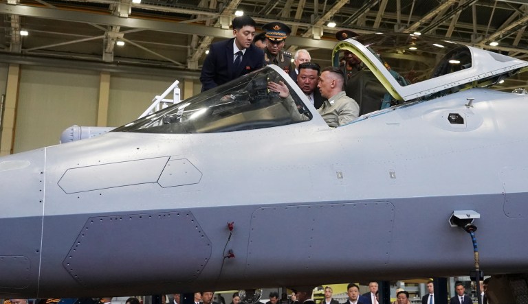 In this photo released by the Khabarovsky Krai region government, North Korean leader Kim Jong Un, center, looks at a military jet cockpit.