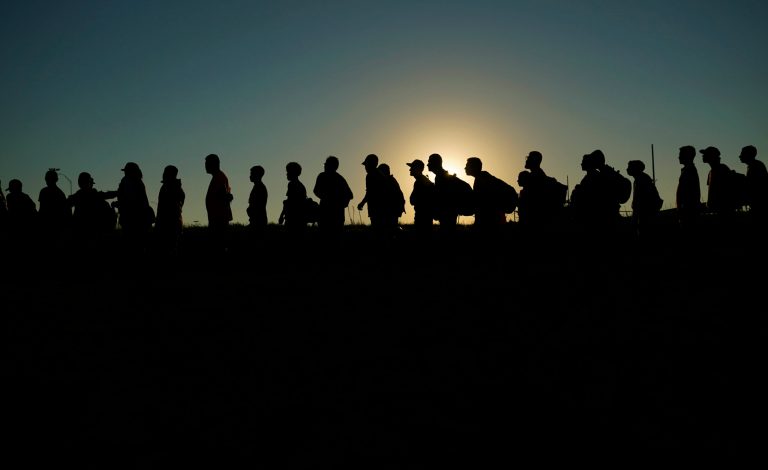 Migrants who crossed the Rio Grande and entered the U.S. from Mexico are lined up for processing by U.S. Customs and Border Protection on Sept. 23, 2023, in Eagle Pass, Texas. 