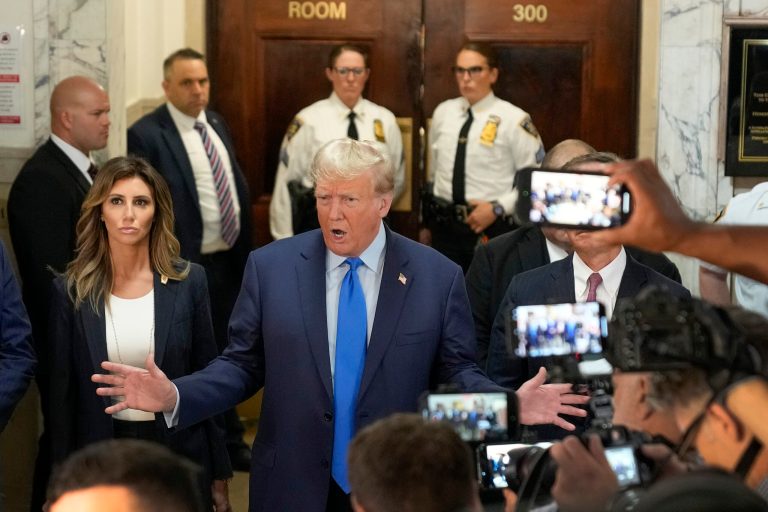 Former President Donald Trump, center, speaks to the media upon arriving at New York Supreme Court, Monday, Oct. 2, 2023. Trump is making a rare, voluntary trip to court in New York for the start of a civil trial in a lawsuit that already has resulted in a judge ruling that he committed fraud in his business dealings.