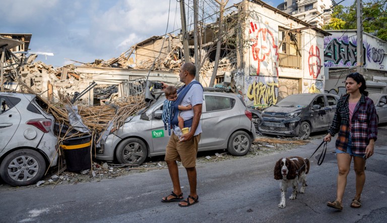 FILE - Israelis inspect the rubble of a building a day after it was hit by a rocket fired from the Gaza Strip, in Tel Aviv, Israel, Sunday, Oct. 8, 2023.