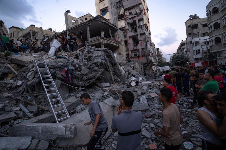 Palestinians look for injured in the rubble of a destroyed residential building following an Israeli airstrike, Tuesday, Oct. 10, 2023. 