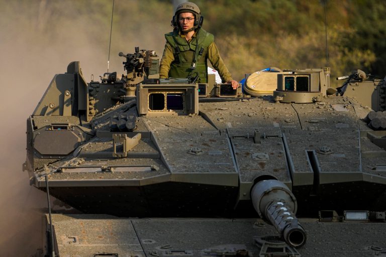 Israeli soldiers drive a tank to a staging area near the border with Lebanon, Wednesday, Oct. 11, 2023. 