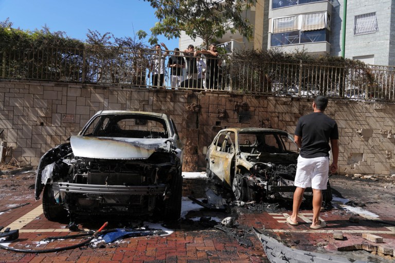 Israelis inspect damaged cars after they were hit by a rocket fired from the Gaza Strip in Ashkelon, southern Israel, Friday, Oct. 13, 2023.