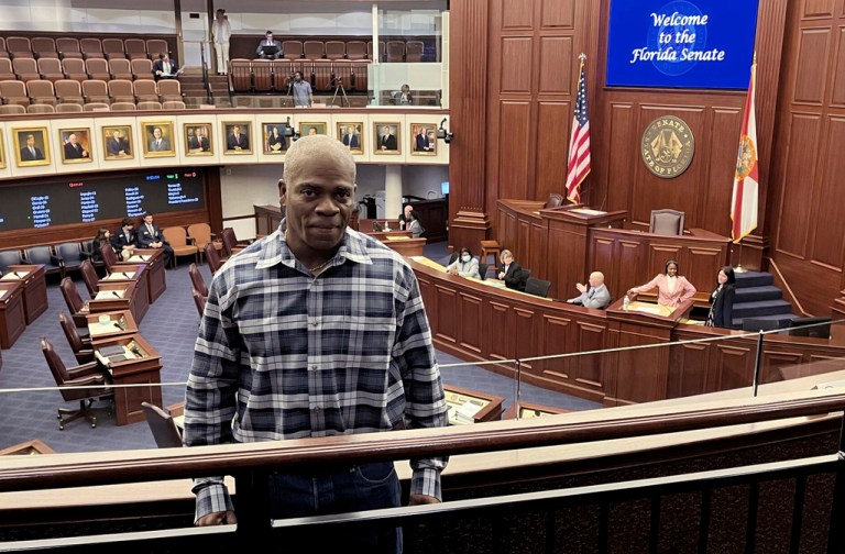 In this photo provided by the Innocence Project of Florida, Leonard Allan Cure poses from the floor of the Florida legislature in Tallahassee, Florida, in April 2023, on the day his compensation bill was passed. 