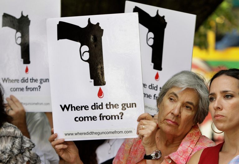 Carol Streiff, of Boston, second from right, displays a placard as Massachusetts state Sen. Sonia Chang-Diaz, right, looks on during a rally in front of the Statehouse in Boston on Tuesday, June 15, 2010. The Massachusetts House approved a sweeping gun bill Wednesday, Oct. 18, 2023, aimed at tightening firearm laws, cracking down on unregistered, so-called ghost guns, and strengthening the stateâs assault-style weapons ban.
