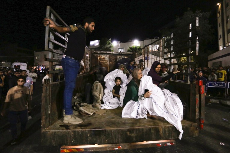 Wounded Palestinians arrive at the al-Shifa hospital on a truck following Israeli airstrikes on Gaza City, central Gaza Strip, Thursday, Oct. 19, 2023. 