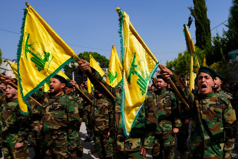 Hezbollah fighters rise their group's flag and shout slogans, as they attend the funeral procession of Hezbollah fighter, Bilal Nemr Rmeiti, who was killed by Israeli shelling, during his funeral procession in Majadel village, south Lebanon, Sunday, Oct. 22, 2023.