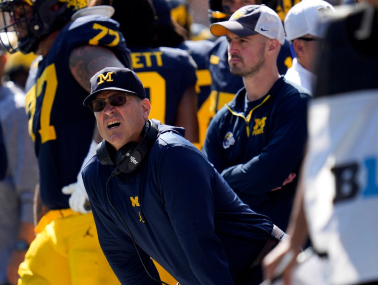 Michigan head coach Jim Harbaugh, front left, watches against Rutgers as analytics assistant Connor Stalions, right, looks on during an NCAA college football game in Ann Arbor, Mich., Sept. 23, 2023. Stalions was suspended by the university last week and is at the center of a sign-stealing scheme that is being investigated by the NCAA. 