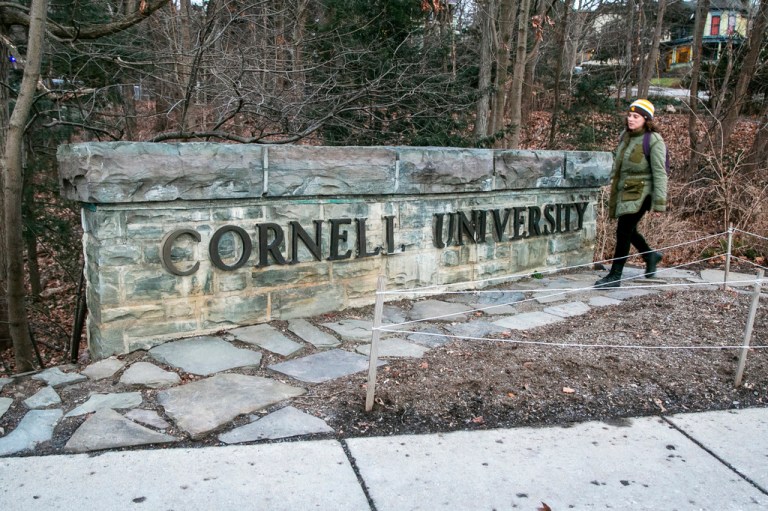A woman walks by a Cornell University sign on the Ivy League school's campus in Ithaca, New York, on Jan. 14, 2022. Cornell University administrators dispatched campus police to a Jewish center after threatening statements appeared on a discussion board Sunday, Oct. 29, 2023. 