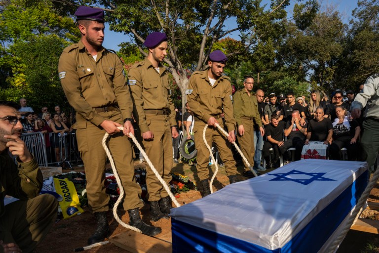 Israeli soldiers lower the coffin of late Israeli Staff Sergeant Shay Arvas on Thursday, Nov. 2, 2023, at the Holon military cemetery on the outskirts of Tel Aviv, Israel. 