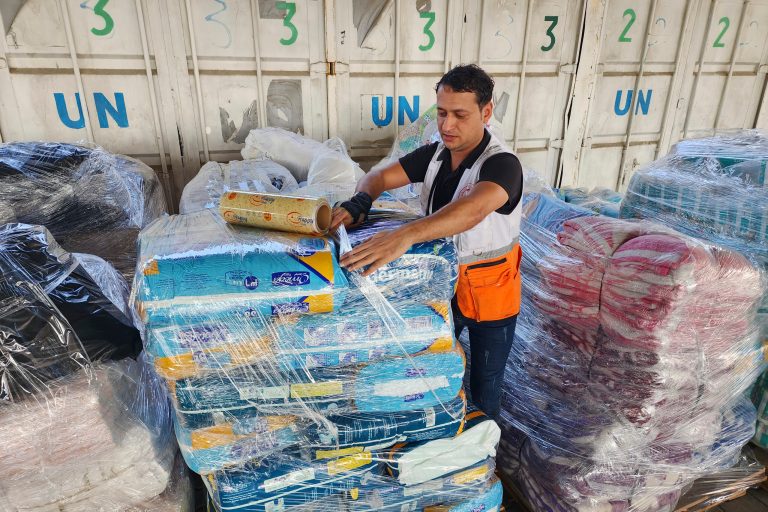 United Nations and Red Crescent workers prepare the aid for distribution to Palestinians at UNRWA warehouse in Deir Al Balah, Gaza Strip, on Monday, Oct. 23, 2023. 