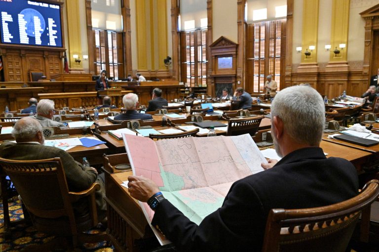 Chuck Payne, a Republican, looks at a map as Nikki Merritt, a Democrat, speaks in opposition of Senate Bill 2EX, newly-drawn congressional maps, in the Senate chambers during a special session at the Georgia State Capitol in Atlanta, Nov. 19, 2021.
