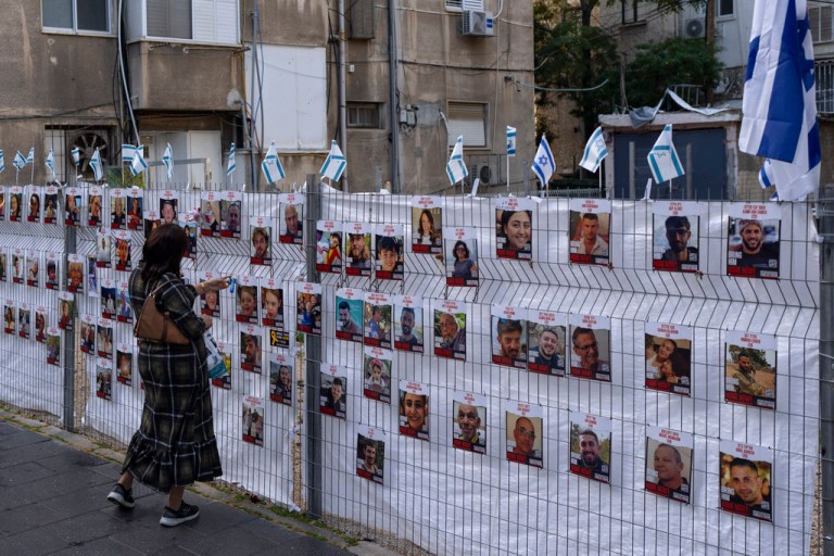A woman looks at photographs of hostages, mostly Israeli civilians who were abducted during the Oct. 7, unprecedented Hamas attack on Israel, in Ramat Gan, Israel, Wednesday, Nov. 22, 2023. 