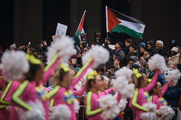 Pro-Palestinian protesters wave their flags as performers move through Sixth Avenue during the Macy's Thanksgiving Day Parade on Thursday, Nov. 23, 2023, in New York.