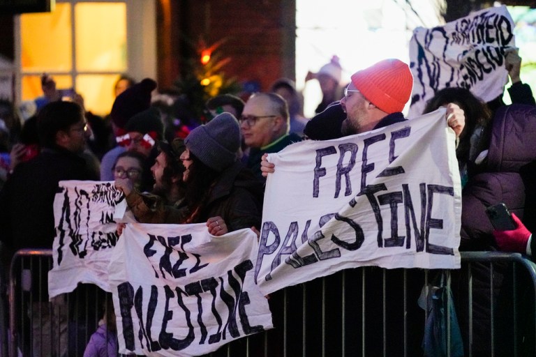 Pro-Palestinian protesters hold signs as President Joe Biden attends the annual Christmas Tree Lighting ceremony in Nantucket, Massachusetts, Friday, Nov. 24, 2023.
