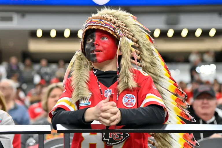 A young Kansas City Chiefs fan, dressed with a headdress and face paint, looks on during an NFL football game against the Las Vegas Raiders, Sunday, Nov. 26, 2023, in Las Vegas.