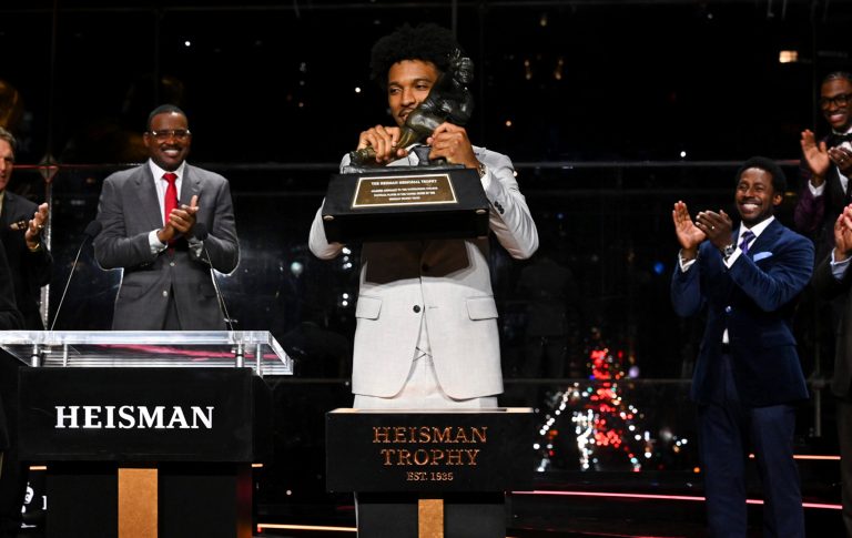 LSU quarterback Jayden Daniels lifts the Heisman Trophy on Saturday, Dec. 9, 2023, in New York.