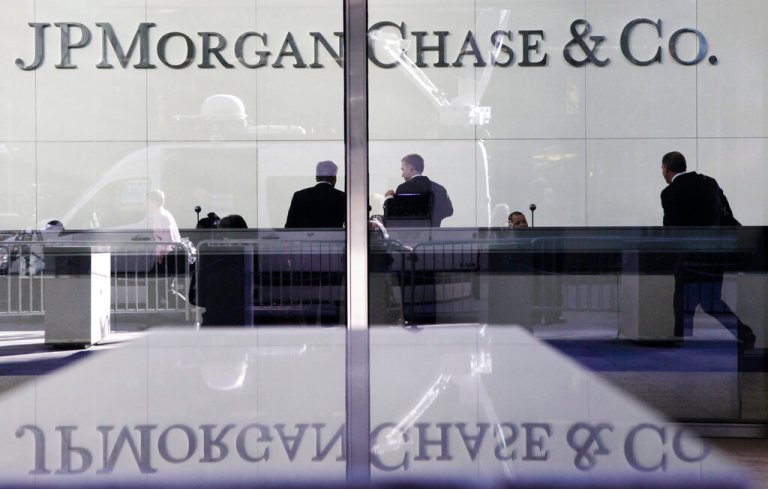 In this May 11, 2012, file photo, people stand in the lobby of JPMorgan Chase headquarters in New York.