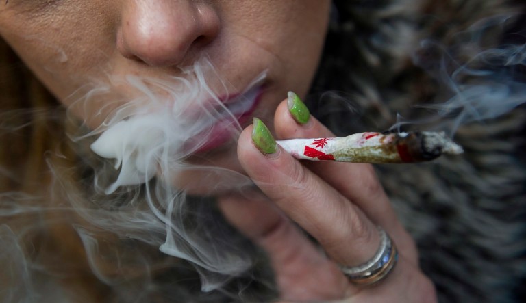 Krissy Calkins smokes a marijuana joint at a "Wake and Bake" legalized marijuana event in Toronto on Wednesday, October 17, 2018. 