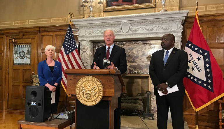 Arkansas Gov. Asa Hutchinson, center, talks at a news conference at the State Capitol in Little Rock, Ark., Wednesday, September 12, 2018, about the state's work requirement for its expanded Medicaid program. Officials said more than 4,300 people on the program lost coverage for not meeting the new work requirement.