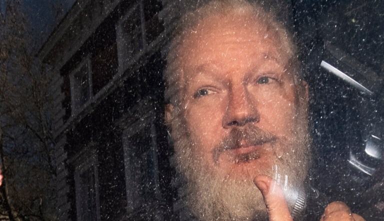 Julian Assange gestures as he arrives at Westminster Magistrates' Court in London, after the WikiLeaks founder was arrested by officers from the Metropolitan Police and taken into custody Thursday April 11, 2019.