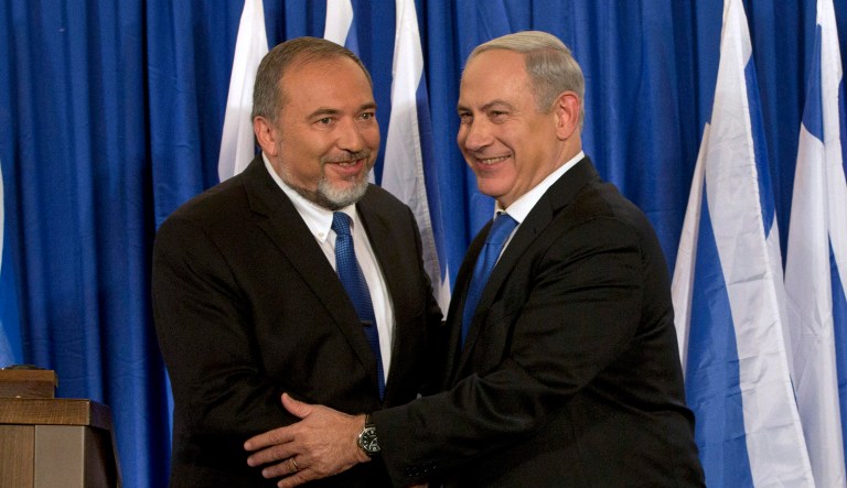 In this Oct. 25, 2012 file photo, Israeli Prime Minister Benjamin Netanyahu, right, and former Israeli Defense Minister Avigdor Lieberman shake hands in front of the media after giving a statement in Jerusalem.