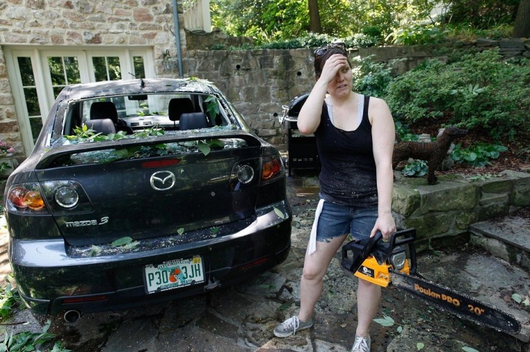 Mari Gillogly, of Arlington, Va., stands alongside her car which was damaged during the violent storms Friday evening, Saturday, June 30, 2012. (Graeme Jennings/Examiner)