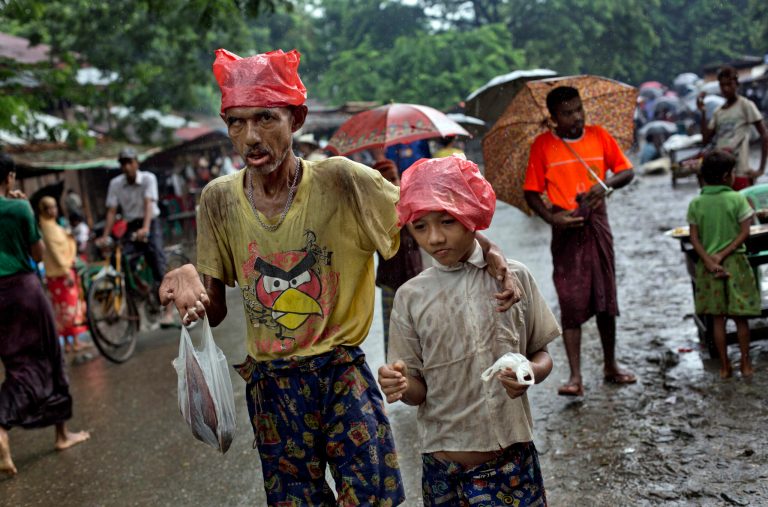 In this June 25, 2014 photo, Rohingya refugees beg for alms at Dar Paing main street, north of Sittwe, Rakhine State, Myanmar. Most Rohingya have lived under apartheid-like conditions in northern Rakhine for decades, with limited access to adequate health care, education and jobs, as well as restrictions on travel and the right to practice their faith.