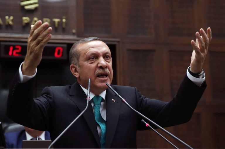 In this Tuesday Jan. 14, 2014 file photo, Turkish Prime Minister Recep Tayyip Erdoğan addresses his supporters at the parliament in Ankara, Turkey. An opposition party leader on Tuesday Feb. 25, 2014, called on Turkey's prosecutors to launch an investigation into Erdoğan for alleged corruption, a day after the disclosure of audio recordings purportedly of him ordering his son to dispose of vast amounts of cash amid a graft investigation.