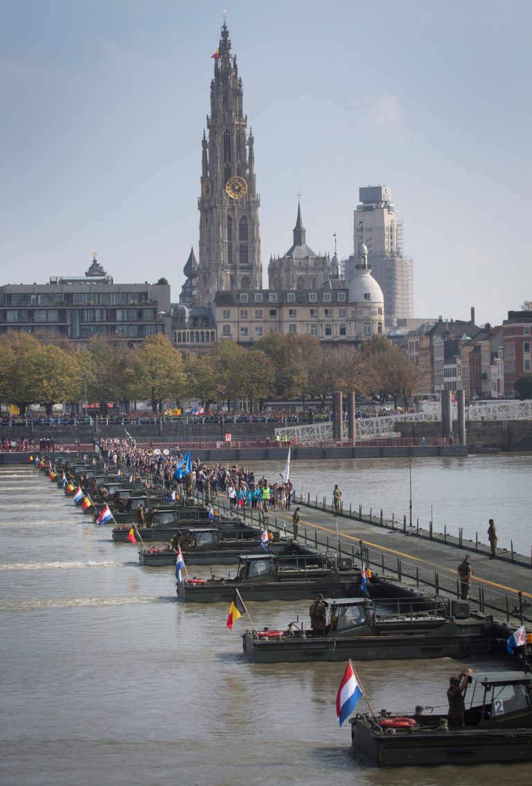 People cross over a floating pontoon bridge on the River Scheldt in Antwerp, Belgium on Friday, Oct. 3, 2014. Antwerp opened it's World War I Centenary program with the pontoon bridge and will allow the general public to cross it for two days. The pontoon bridge is an actual reconstruction of the original that spanned the River Scheldt at the start of the war in 1914 and played a major role in the defense of Antwerp. It was used by the Belgian army under King Albert I as well as the British Expeditionary Force under Winston Churchill. (AP Photo/Virginia Mayo)