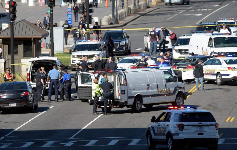 A woman, center, is taken into custody on Capitol Hill in Washington, Wednesday. Police say a driver struck a U.S. Capitol Police cruiser near the U.S. Capitol and was taken into custody. (AP Photo/Susan Walsh)