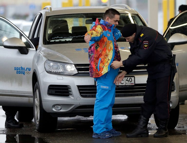 A Russian police officer searches a driver as his vehicle is also screened at an entrance to the Sochi 2014 Olympic Winter Games park, Thursday, Jan. 23, in Sochi, Russia. (AP Photo/David J. Phillip)