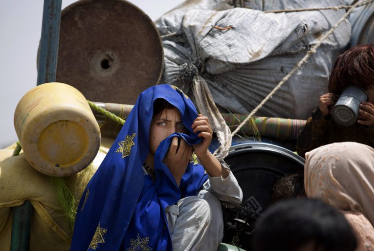 A Pakistani tribal girl sits next to her belongings on a truck after arriving to Bannu, Pakistan, Wednesday, June 18, 2014. Thousands of villagers fled as Pakistani army relax a curfew in troubled North Waziristan. Pakistani jets pounded targets in the country's northwest in major offensives  designed to root out safe havens in the volatile region. (AP Photo/B.K. Bangash)