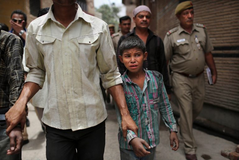   A young Indian bonded child laborer cries as he is walked away after being rescued during a raid by workers from Bachpan Bachao Andolan, or Save the Childhood Movement, at a garment factory in New Delhi, India, Tuesday, June 12, 2012. Raids on factories in the Indian capital revealed dozens of migrant kids hard at work Tuesday despite laws against child labor. Police rounded up 26 children from three textiles factories and a metal processing plant, but dozens more are believed to have escaped. Those captured had all come to New Delhi from the states of Bihar and Uttar Pradesh. (AP Photo/Kevin Frayer)  