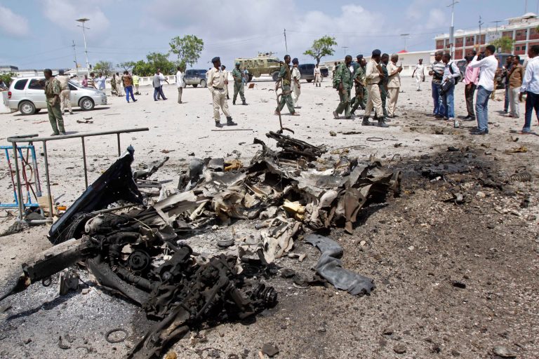 Somali soldiers stand near the wreckage of a suicide car bomb near the Somali parliament in Mogadishu, Somalia, Saturday, July 5, 2014. A Somali police officer says troops have thwarted an attack by a suicide bomber outside the heavily guarded parliament headquarters. Capt. Mohamed Hussein, a senior Somali police officer says troops stopped a suicide car bomber who detonated his explosive-laden car at a checkpoint near the entrance to Somalia's parliament. (AP Photo/Farah Abdi Warsameh)