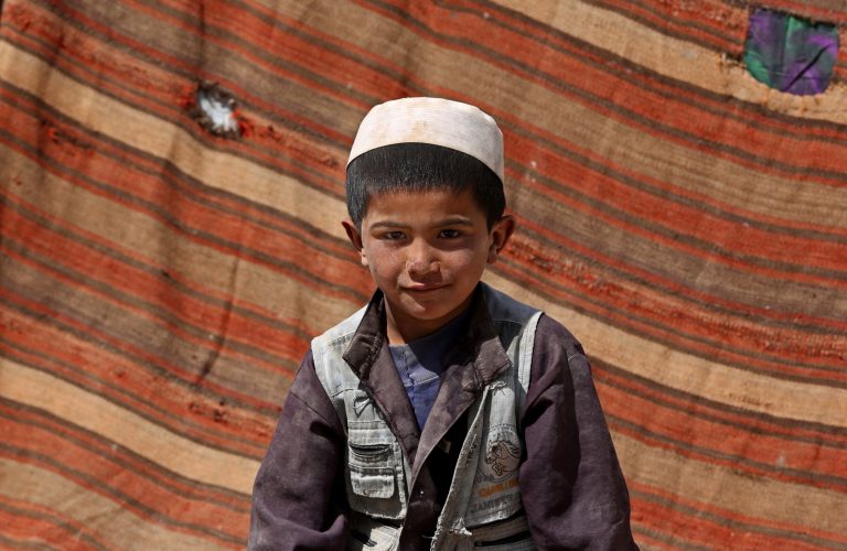 A Afghan survivor poses for a photograph near the site of Friday's landslide that buried Abi-Barik village in Badakhshan province, northeastern Afghanistan, Tuesday, May 6, 2014. Authorities tried to help families displaced by the torrent of mud that swept through Abi-Barik village after hundreds were killed. (AP Photo/Massoud Hossaini)
