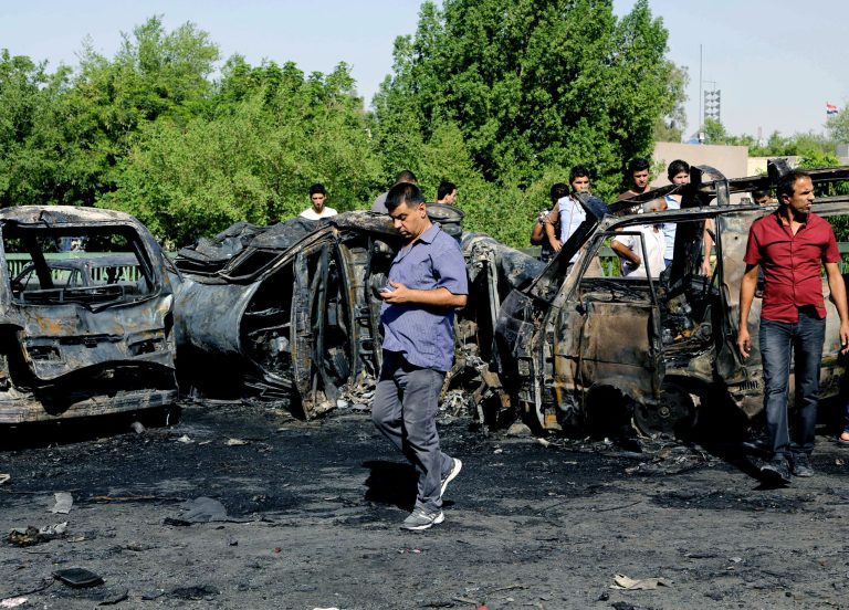 Civilians inspect the site a car bomb explosion in southeastern neighborhood of New Baghdad, Iraq, Wednesday, Sept. 10, 2014. Twin car bombs near pet and vegetable markets in Baghdad killed and wounded dozens of people, Iraqi officials said. (AP Photo/ Karim Kadim)