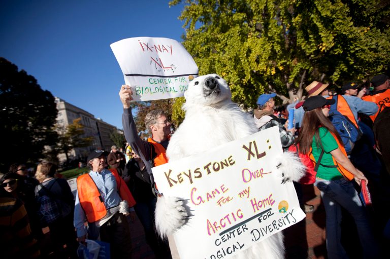 Demonstrators march with a replica of a pipeline during a protest to demand a stop to the Keystone XL tar sands oil pipeline outside the White House in November 2011. (AP Photo/Evan Vucci)