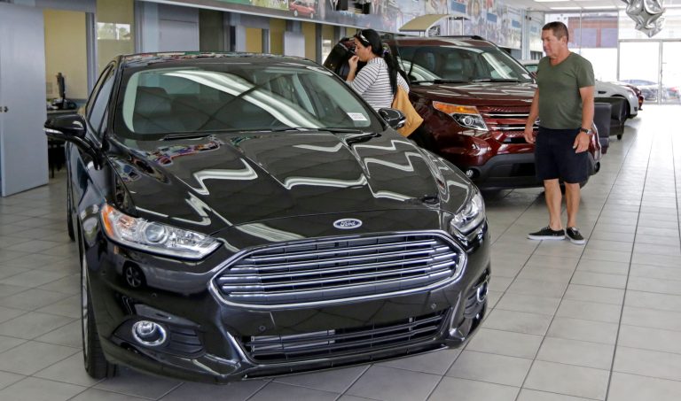 In this photo taken Aug. 21, 2014, Orestes Perez, right, and his niece Yanuska Perez, check a 2013 Ford Fusion SE at a local dealership in Hialeah, Fla. The Commerce Department reports on business orders for durable goods in July on Tuesday, Aug. 26, 2014. (AP Photo/Alan Diaz)