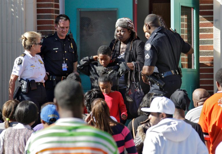   Anxious parents crowd the entrance to Brown Middle School where students were brought after being evacuated from Finch Elementary School in Atlanta Monday, Dec. 3, 2012. Officials say at least 31 people were taken to hospitals after apparently being overcome by carbon monoxide at Finch Elementary School in Southwest Atlanta. Firefighters responding shortly after school began detected high and unsafe levels of carbon monoxide near a furnace at the school, said Atlanta fire Capt. Marian McDaniel. (AP Photo/Atlanta Journal-Constitution,Bob Andres) MARIETTA DAILY OUT; GWINNETT DAILY POST OUT; LOCAL TV OUT; WXIA-TV OUT; WGCL-TV OUT  