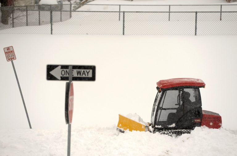 A Baltimore County worker clears snow from a walkway in Towson, Md. Thursday, Feb. 13, 2014. The storm was the biggest in Maryland in four years, prompting a state of emergency declaration by the governor. (AP Photo/Steve Ruark)