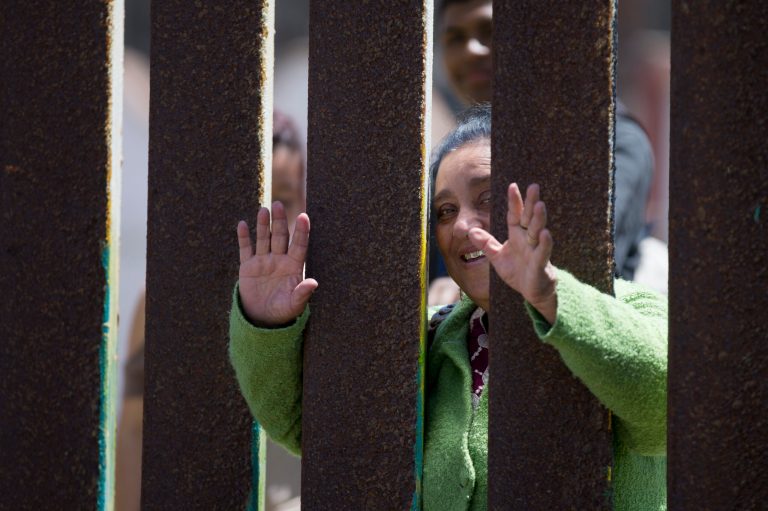 Juana Lara waves through the border wall to her granddaughter Eva Lara during a brief visitation near where Mexico and the United States meet at the Pacific Ocean in San Diego. Lara, who lives in the United States legally through legislation that temporarily prevents young immigrants from being deported, has not seen her grandmother since the family left Mexico when she was three years old. (AP Photo/Gregory Bull)