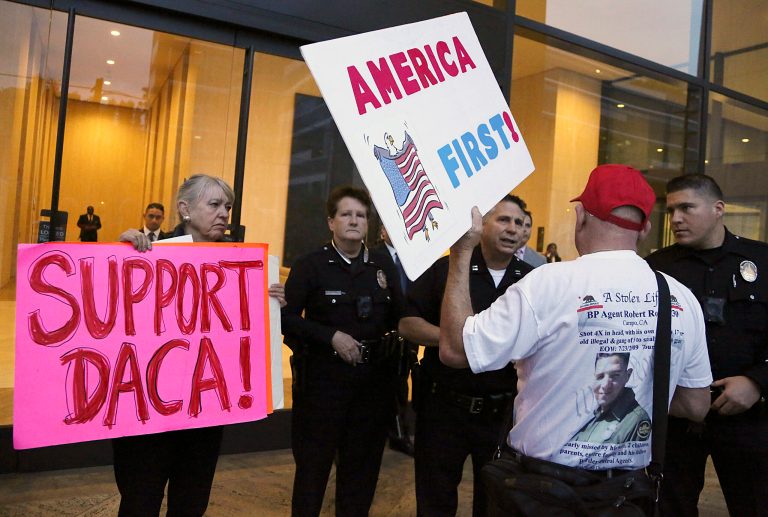 A supporter of President Donald Trump challenges police officers and a Deferred Action for Childhood Arrivals (DACA) program during a rally outside the office of California Democratic Sen. Dianne Feinstein in Los Angeles, Wednesday, Jan. 3, 2018. (AP Photo/Reed Saxon)