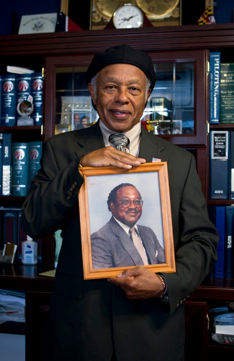 In this May 16, 2013, photo, Abdulah Salim, Jr. hold the photograph of his father Dr. Reginald A. Hawkins who was a prominent Charlotte civil rights leader, in Silver Spring, Md. In the spring of 1963, a Hawkins led 65 people on a four-mile march from an African American college to the center of Charlotte's downtown. ( AP Photo/Jose Luis Magana)