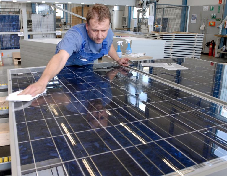 A technican polishes a solarpanel modul in a assembly line of the Solarworld factory in Freiberg, Germany, in a Sept. 4, 2006 photo. (AP Photo/Matthias Rietschel)