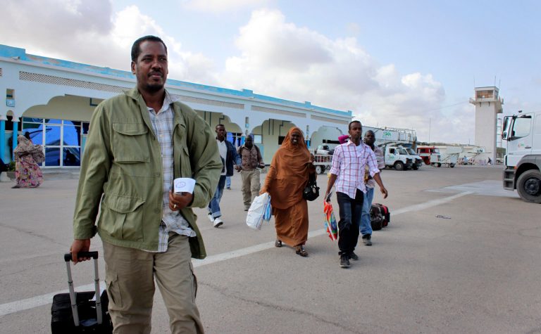   In this photo taken Friday, June 8, 2012, Abdikhafar Abubakar prepares to board a plane back to Minneapolis after returning to Mogadishu to visit his mother for the first time in decades, at the airport in Mogadishu, Somalia. The seaside Somali capital is enjoying a peace that, except for the infrequent attack, has lasted the better part of a year and Somalis who fled decades of war are coming back, as are U.N. workers who long operated out of Nairobi, the capital of neighboring Kenya. (AP Photo/Jason Straziuso)  