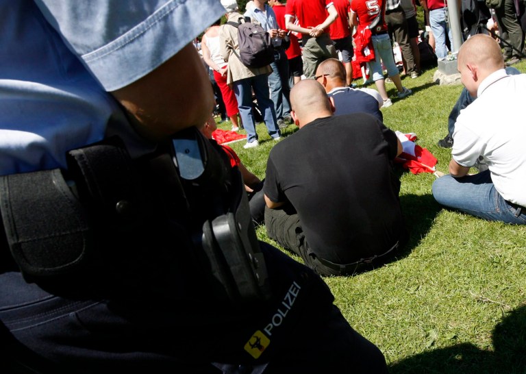 FILE - In this Aug. 1, 2007 file photo police watches neo-Nazis during national holiday celebrations on the Ruetli meadow above lake Lucerne in Switzerland. Switzerland's top court has ruled Wednesday, May 21, 2014, that a Nazi salute isn't illegal racial discrimination provided it's intended as a personal statement. The Federal Tribunal's ruling, entitled 