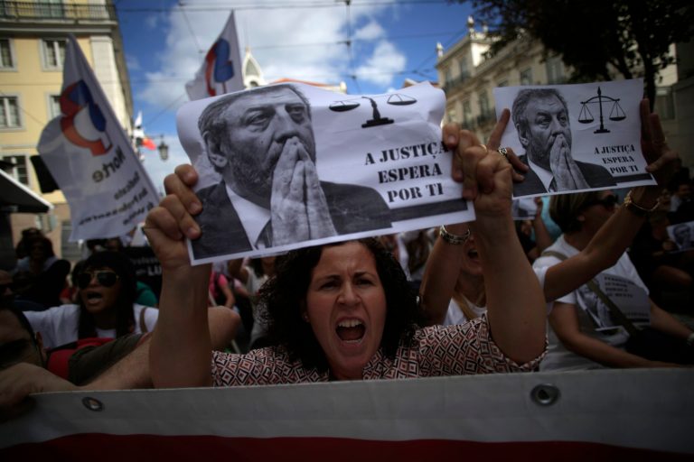 A woman holding up a sheet of paper with the face of the Portuguese Education Minister Nuno Crato, shouts slogans during a protest by Portuguese teachers in Lisbon, Sunday, Oct. 5, 2014. Seven teachers' trade unions organised the march Sunday to protest the government's education policies. Sign reads in Portuguese: 