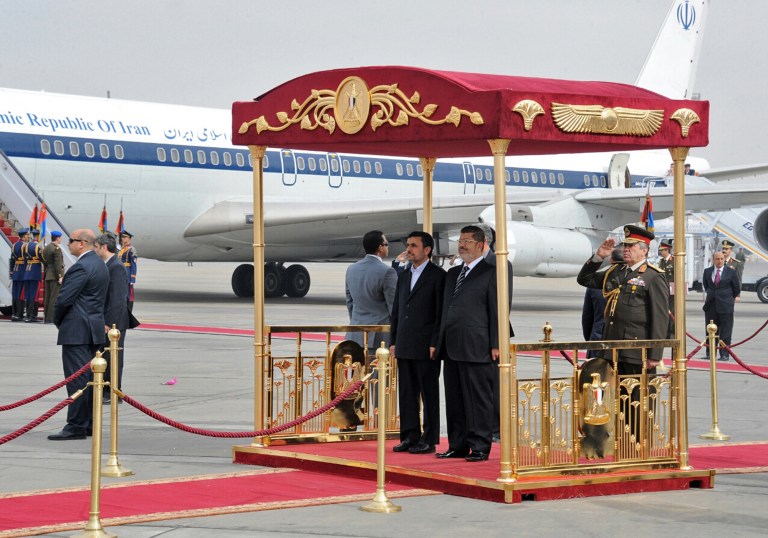 FILE -- In this Tuesday, Feb. 5, 2013 file photo released by the Egyptian Presidency, Iran's President Mahmoud Ahmadinejad, center, and Egyptian President Mohammed Morsi, center right, participate in an arrival ceremony at the airport in Cairo, Egypt. Egypt airport officials said Saturday, March 30, 3013 that the first commercial flight to Tehran has left from Cairo, the first such direct flight between the two countries in more than three decades. Relations between Iran and Egypt are witnessing a thaw following the election of Islamist President Mohammed Morsi in June, 2012. (AP Photo/Egyptian Presidency, File)
